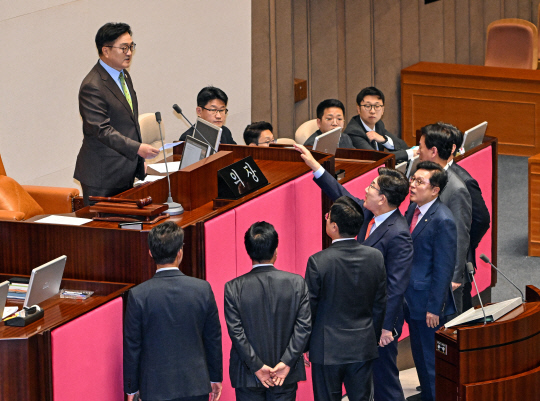 우원식 국회의장이 24일 국회 본회의에서 한덕수 대통령 권한대행 국무총리가 추가경정예산안 시정연설을 마친 뒤 한 대행에게 착석을 요구, 훈계성 발언을 하자 권성동 원내대표 등 국민의힘 의원들이 연단 앞으로 나와 우 의장에게 항의하고 있다.<국회사진기자단·연합뉴스>